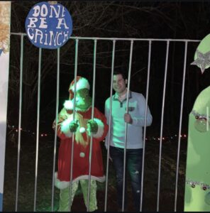 Bentley Burns posing with the Grinch during a holiday event, providing Christmas party entertainment